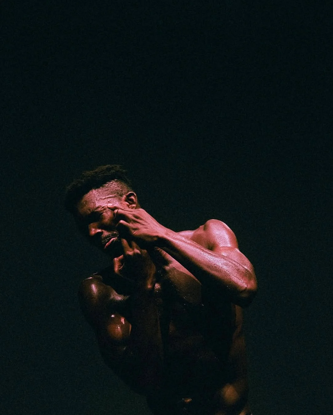 Oulouy performing Black, one hand covering his face.