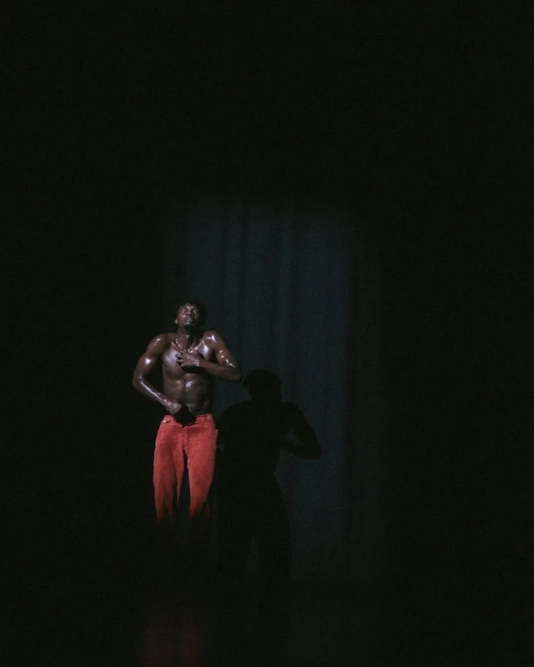 Oulouy under a spotlight on a dark stage.