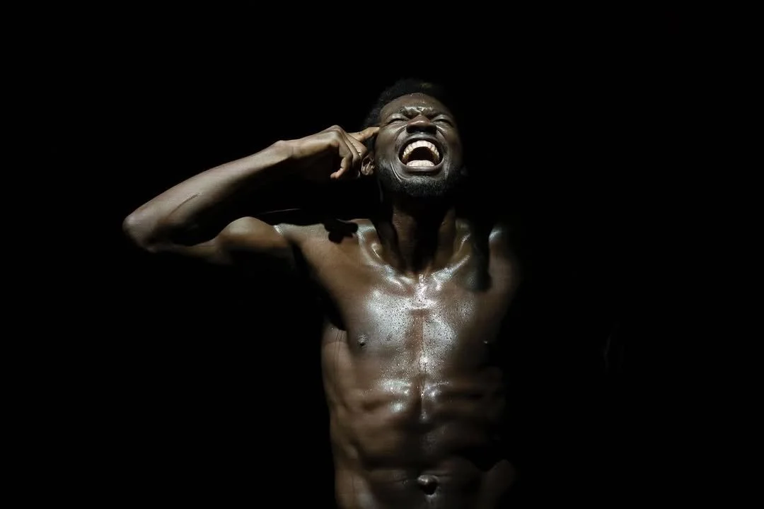 Oulouy holding his head, performing Black.