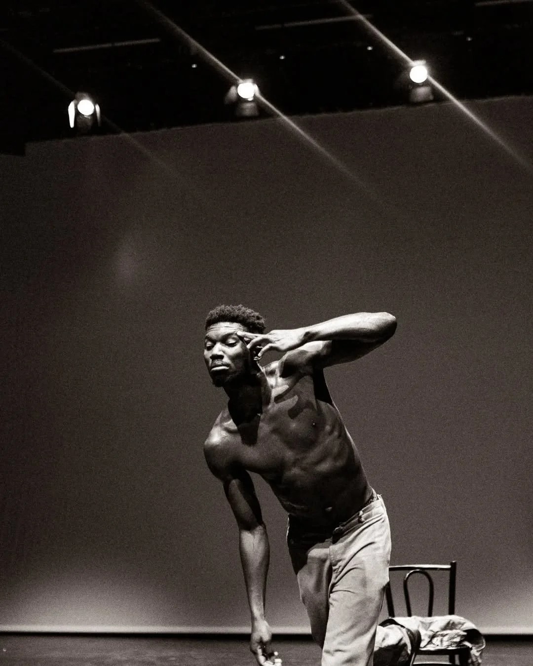 Oulouy performing on stage, leaning forward with one hand near his face.